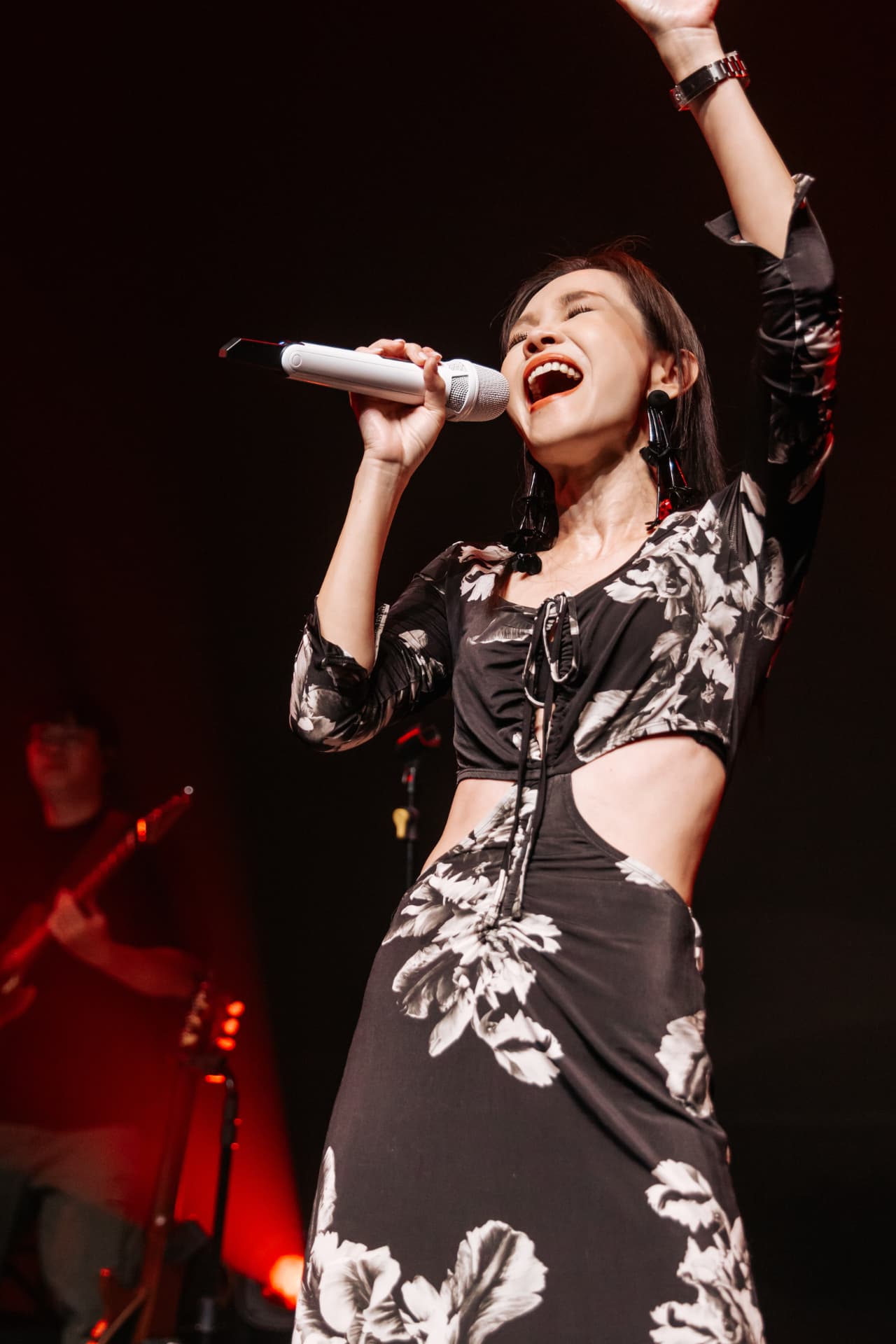 Singer raising one hand during an energetic performance