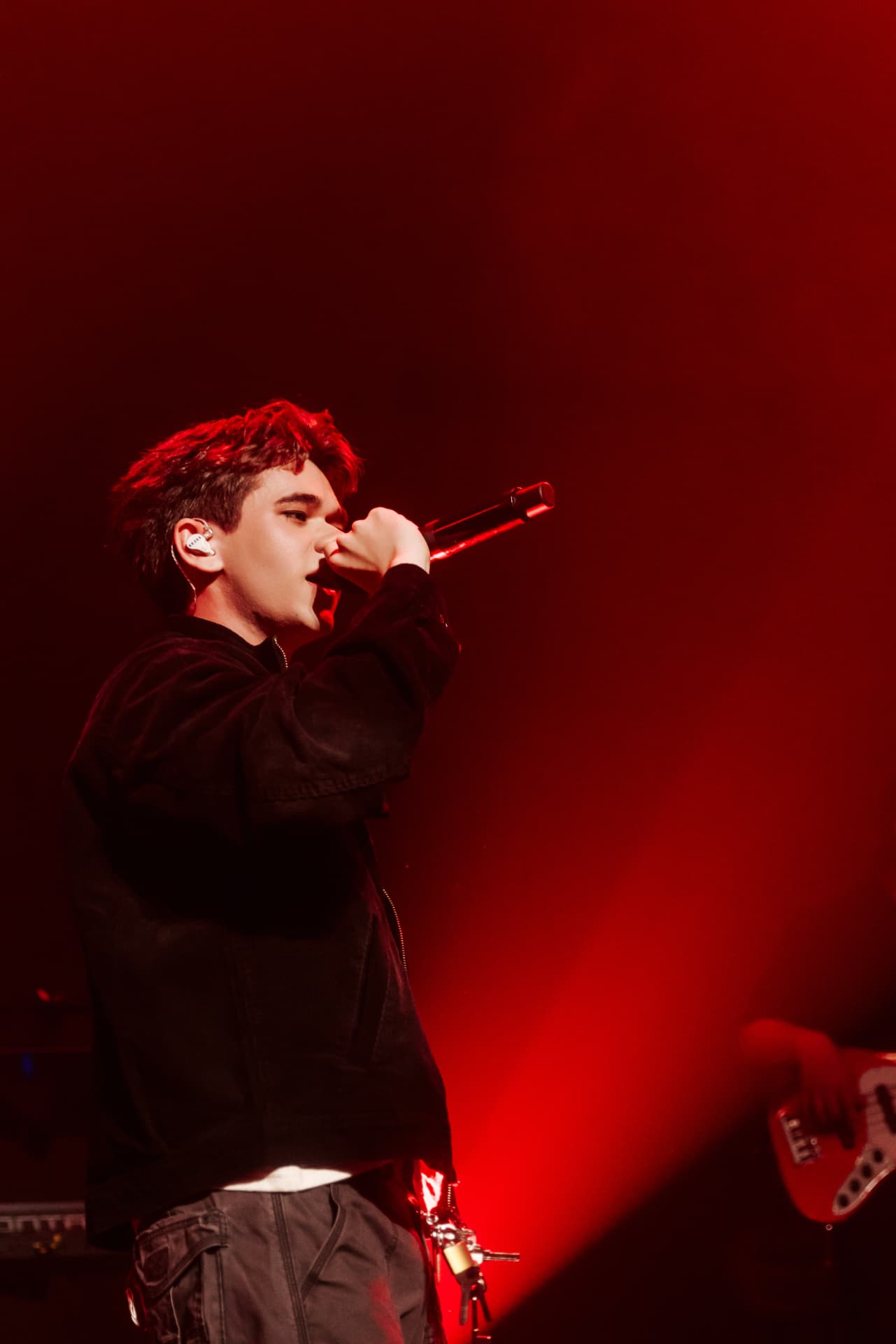 Vocalist performing against intense red stage lighting