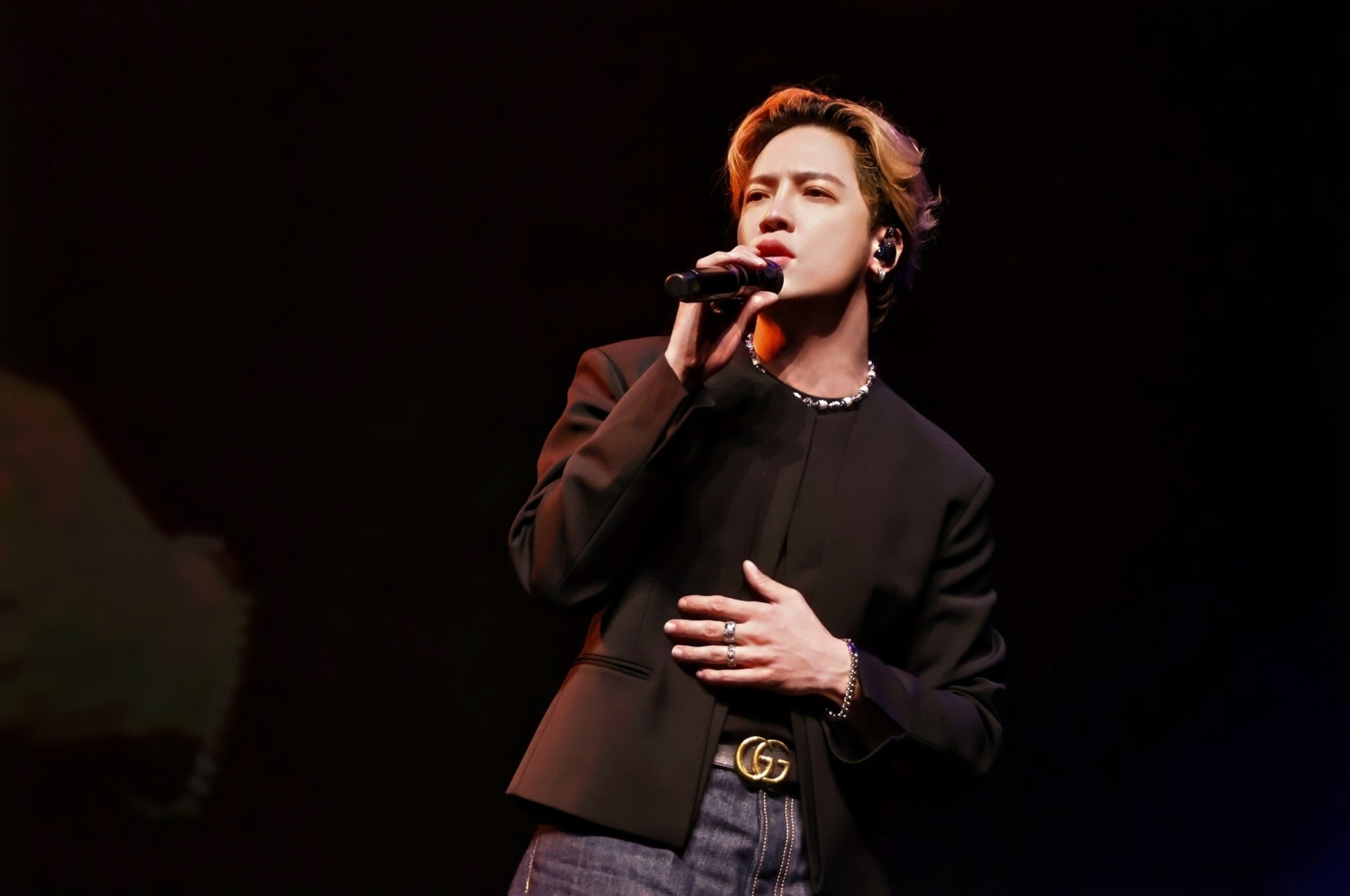 Male vocalist performing under a focused stage light